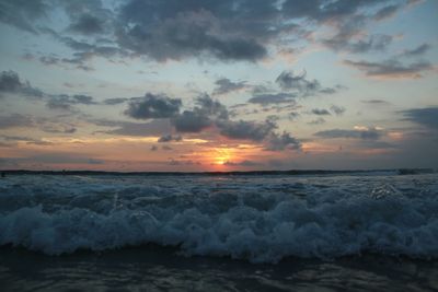 Scenic view of sea against dramatic sky during sunset