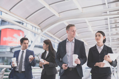 Business people discussing while standing on elevated walkway