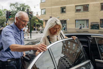 Senior couple getting inside taxi in city