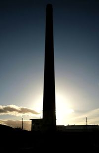 Low angle view of silhouette built structure against sky