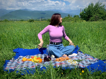 Full length of woman sitting on field