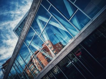 Low angle view of modern glass building against sky