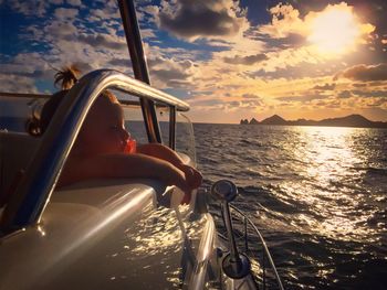 Boat sailing on sea against sky during sunset