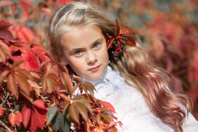 Portrait of cute girl by leaves during autumn