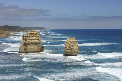 Rock formations in sea against sky