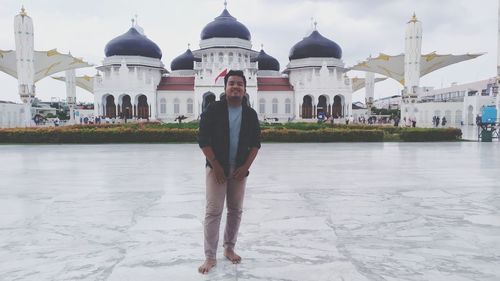 Full length of man standing outside temple against building