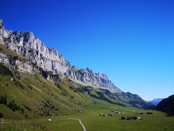 Scenic view of mountains against clear blue sky