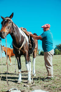 Mature man preparing his horse