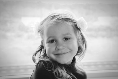 Close-up portrait of smiling girl wearing flower while standing outdoors