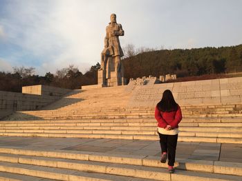 Rear view of woman standing on steps