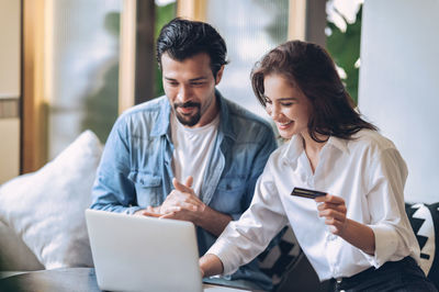 Couple pay buy with credit card on internet using computer to shopping online during quarantine