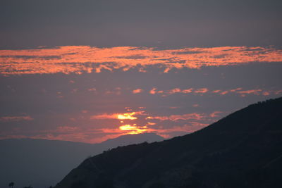 Low angle view of silhouette mountains against sky during sunset