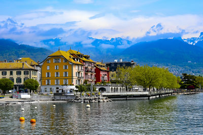 Houses by lake against sky