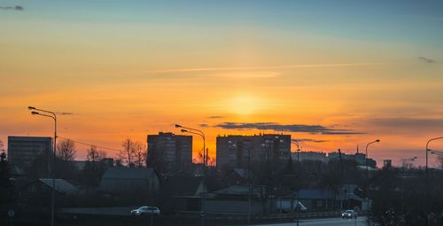 Silhouette buildings in city against sky during sunset