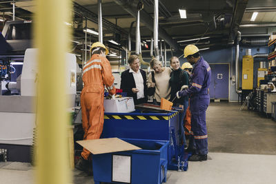 Multi-generation family discussing with male blue-collar workers working in industry