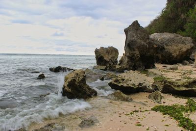 Rocks on beach against sky