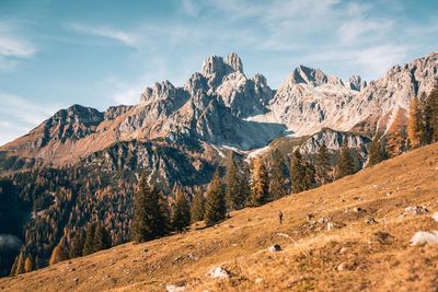 Rear view of woman walking on mountain against sky