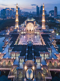 View of illuminated buildings in city at dusk