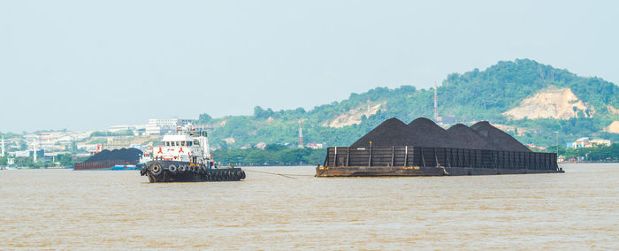 Scenic view of sea by buildings against sky