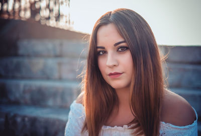 Close-up portrait of a beautiful young woman sitting on steps
