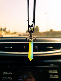 Close-up of necklace hanging in car