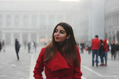 Portrait of woman standing in city during winter