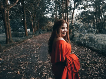 Portrait of smiling young woman in forest