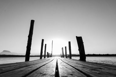 Wooden pier in sea against clear sky