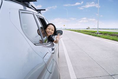 Portrait of girl waving from car