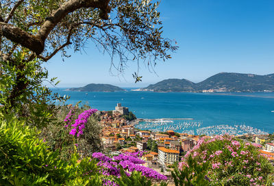 Scenic view of sea by buildings against blue sky