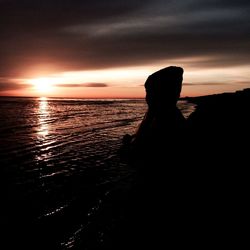 Silhouette of people on beach at sunset