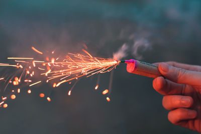 Close-up of man igniting firecracker outdoors