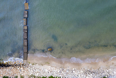 Aerial top view from drone to the seashore with old concrete pier