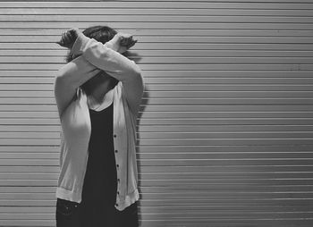 Close-up of woman standing against shutter