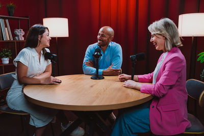 Side view of young woman sitting on table
