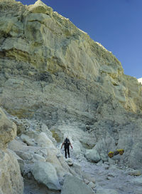 Low angle view of woman climbing on mountain