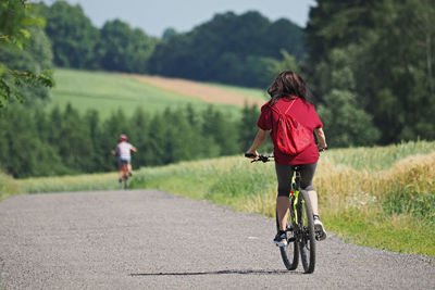 Mother with her son ride a bike in the summer countryside