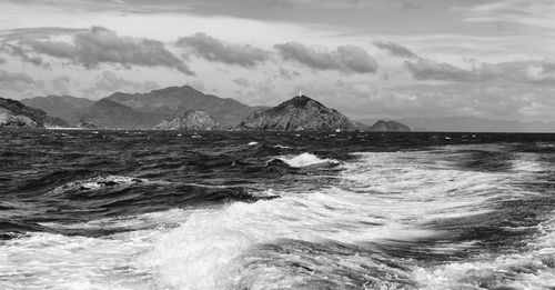 Scenic view of sea and mountains against sky