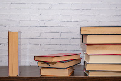 Stack of books on table against wall