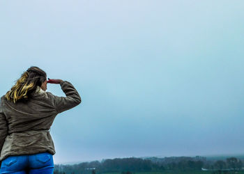 Rear view of man standing against clear sky