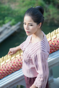 High angle view of woman standing by railing on staircase