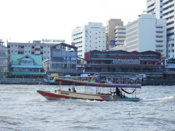 Boats in city against sky during winter