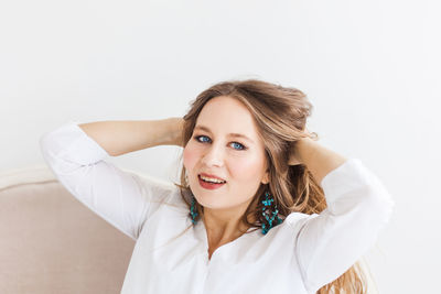 Portrait of a smiling young woman against white background