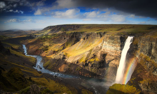 Scenic view of waterfall against sky