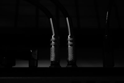 Close-up of metal pipes on table in the dark