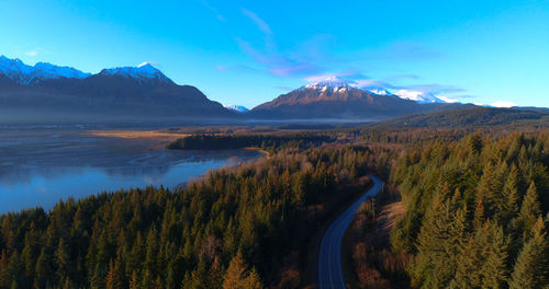 Panoramic view of trees and mountains against blue sky