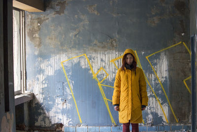 Rear view of woman standing against blue wall