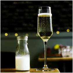 Close-up of champagne by milk on table