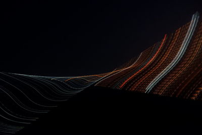 Light trails on road against sky at night