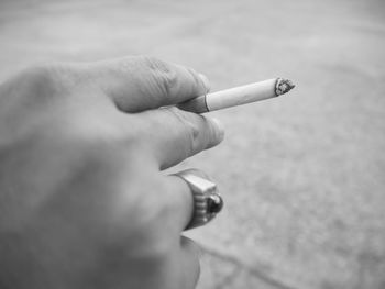 Close-up of hand holding cigarette
